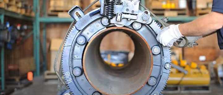 A worker clamping down a section of pipe with the Porta-Lathe as we look inside.