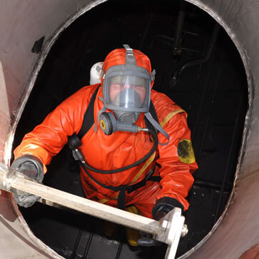 PSS employee in full PPE climbing on a ladder.