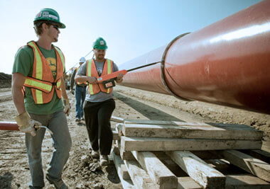 Workers inspecting pipes using PSSI's SPY brand tools.