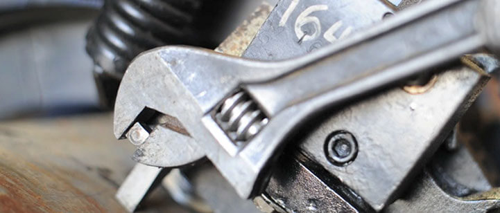 A close up of a wrench tighetning a bolt.